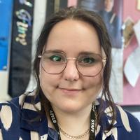 Teacher wearing glasses smiling at camera