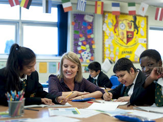 teacher and pupils at desk smiling