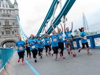 Run the River participants run over Tower Bridge, cheering