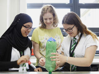 Teacher and pupils engaged in a science lesson with bottle