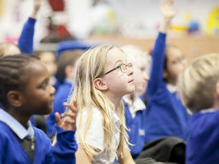 pupils in class raise their hands