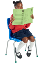 A seated schoolgirl peeks at the camera from behind an open exercise book. 