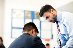 a teacher helps a pupil with his work