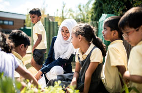 Teacher and students outside in the school garden in summertime
