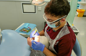 Image of Umair doing dental work practice on a test dummy