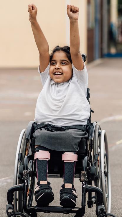 A child playing on the school playground in their wheelchair.