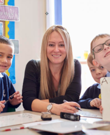 Female teacher smiling with primary school students