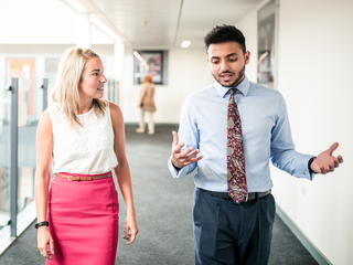 teacher and coach have a conversation in school hallway