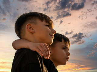 Two primary pupils watching a sunset.