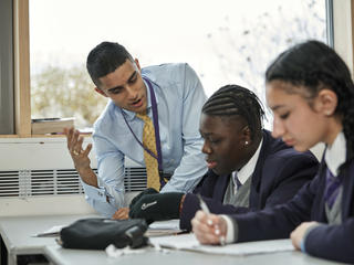 Male teacher teaching two secondary school students