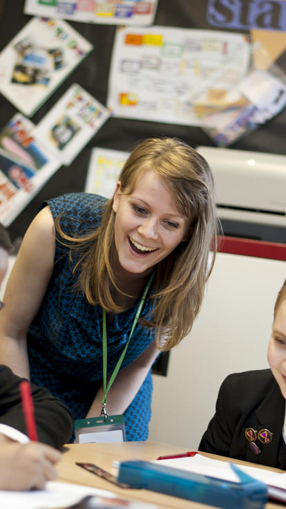 A teacher helps pupils with their work