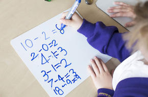 Primary student math workings on a sheet of paper