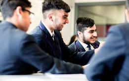 Secondary school pupils laughing in class.